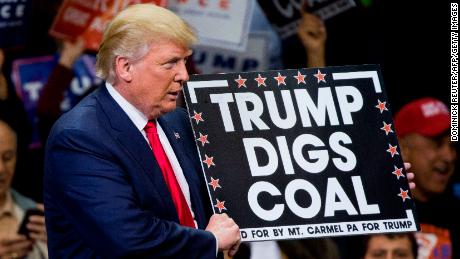 Then-Republican presidential nominee Donald Trump holds a sign supporting coal during a rally in Pennsylvania on October 10, 2016. President Trump&#39;s moves to gut greenhouse gas regulations were applauded by many in the fossil fuel industry, but coal jobs continued to decline on his watch.
