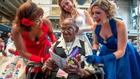 The Victory Belles singing group gives a birthday card to Lawrence Brooks, a Second World War veteran.