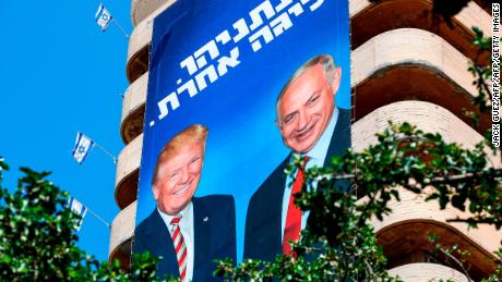 A giant Israeli Likud Party election banner hangs from a building in Tel Aviv showing Netanyahu shaking hands with Trump, with a caption above reading in Hebrew &quot;Netanyahu, in a league of his own.&quot;