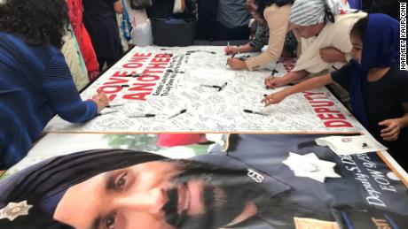 Mourners sign a banner dedicated to Dhaliwal on Wednesday, in a hall near the arena where the funeral is being held.