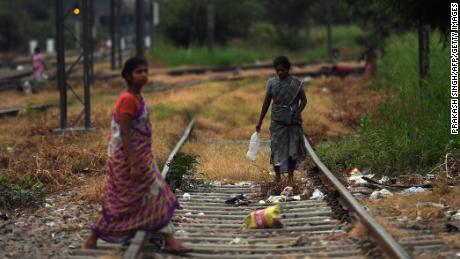 Women walking on train tracks in an area where people defecate in the open near Nizamuddin railway station in New Delhi on September 27, 2019.
