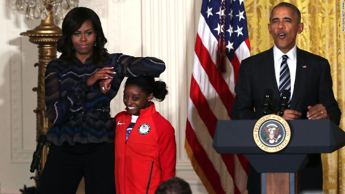 First lady Michelle Obama rests her elbow on Biles&#39; head as President Barack Obama speaks during an Olympic athletes event at the White House in September 2016.