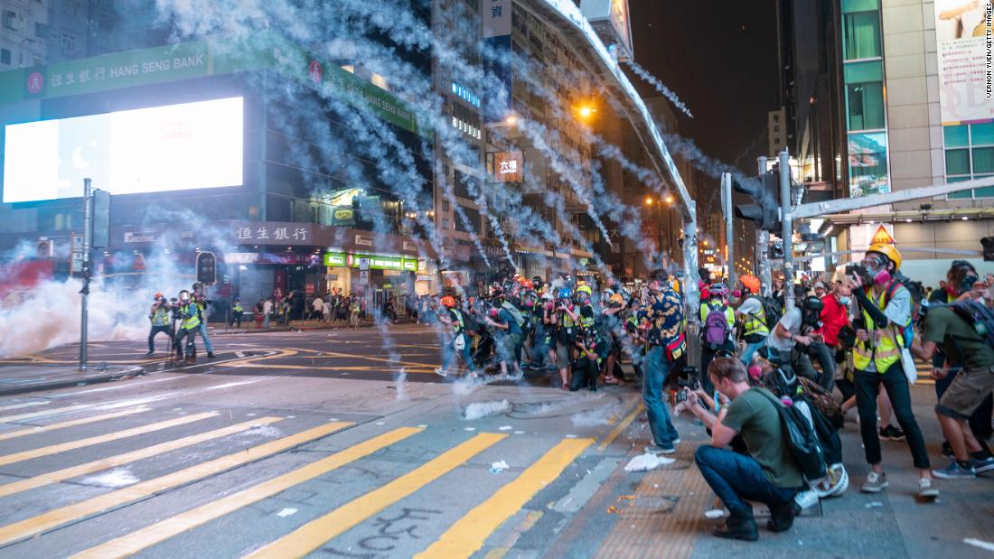 Tear gas smoke is seen exploding over reporters during an anti-government protest in Mong Kok district in Hong Kong on October 27.