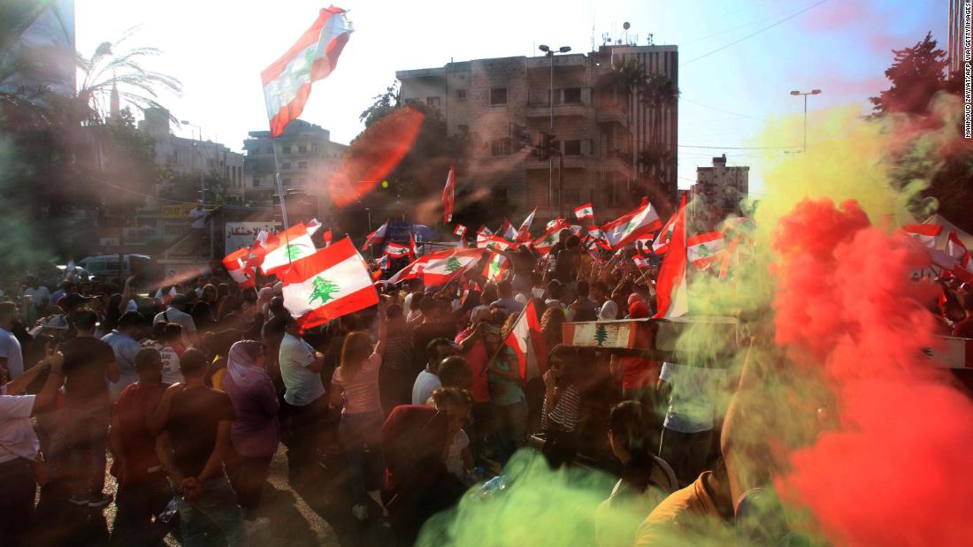 Demonstrators wave flags as they gather in the southern city of Sidon on October 19.