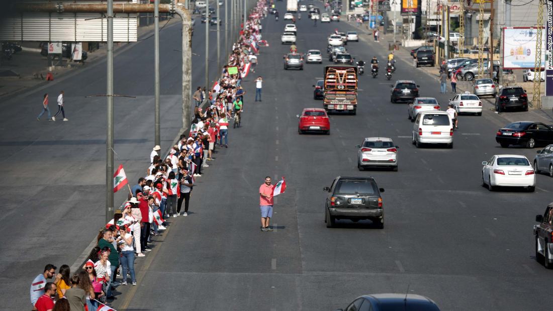 Protesters hold hands to form a human chain along a coastal highway near Beirut on Sunday, 十月 27.