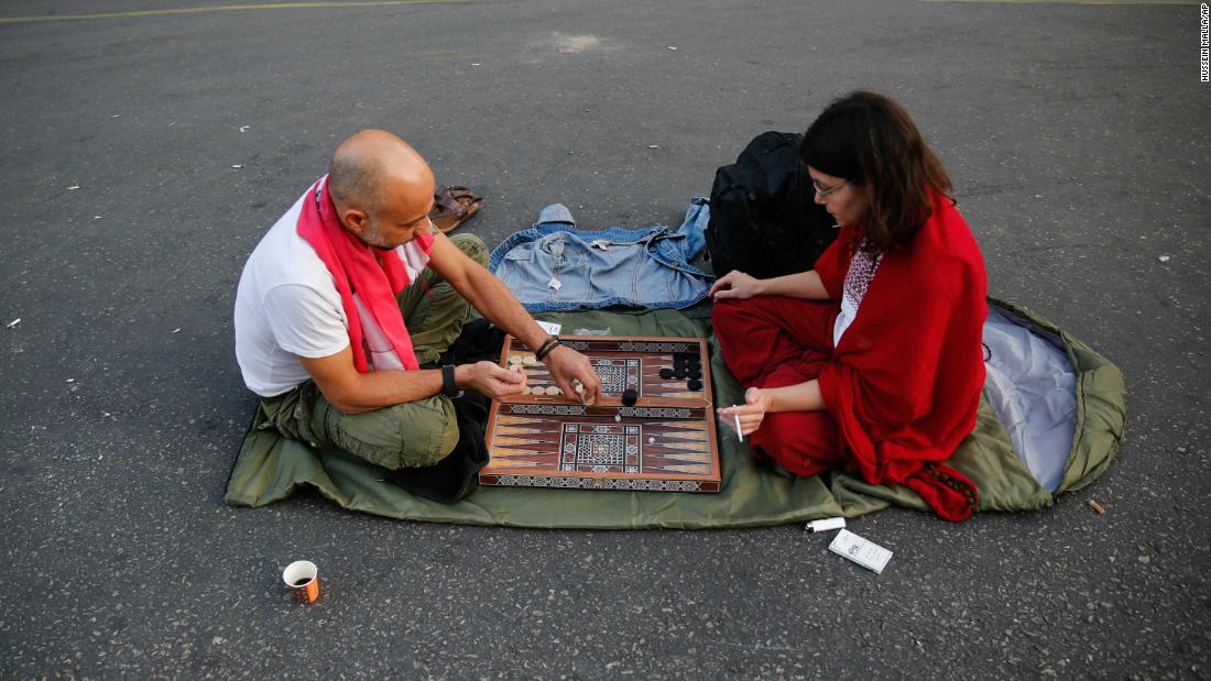 Anti-government protesters play a dice game as they block a main highway during during demonstrations.