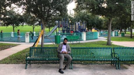 Bashirul Shikder looks through photos of his children on his phone in a park where they all used to play.