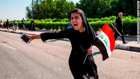 An Iraqi girl holding a national flag and a cell phone chants at a demonstration outside the port of Umm Qasr on November 5.