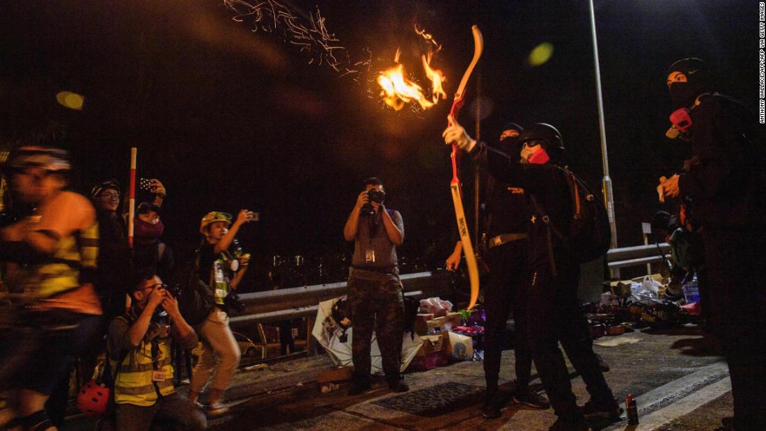 A protester releases a flaming arrow to light a barricade at The Chinese University of Hong Kong (CUHK), 水曜日, 11月 13.