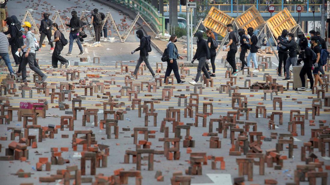 Protesters walk past barricades of bricks on a road near the Hong Kong Polytechnic University on November 14.