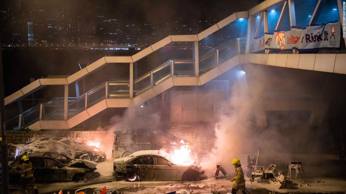 Firefighters put out a burning car set on fire by protesters near Hong Kong Polytechnic University in the Tsim Sha Tsui district on November 18.