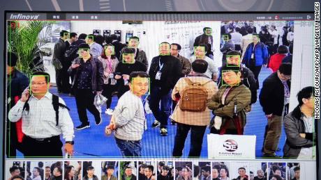 A screen shows visitors being filmed by AI security cameras with facial recognition technology at the 14th China International Exhibition on Public Safety and Security at the China International Exhibition Center in Beijing on October 24, 2018.