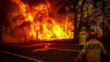 Fire and rescue personnel monitor a bushfire as it burns near homes on the outskirts of Bilpin on Thursday, December 19.