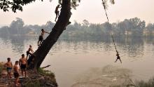 Children swing into the Penrith river during a heatwave in Sydney on December 19.