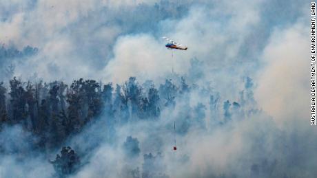 A helicopter dumping water on a fire in the East Gippsland region of Victoria, Australia.