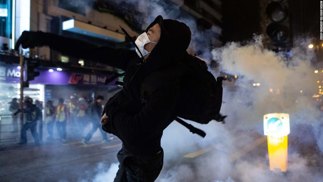 A protester reacts after police fire tear gas to disperse bystanders in the Jordan district of Hong Kong, early on December 25.