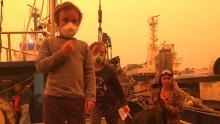 Ike, 5, and his sister Kalani, 6, with their mother Louise during a tense weekend on the family's fishing vessel where they took shelter from flames in Eden, NSW.