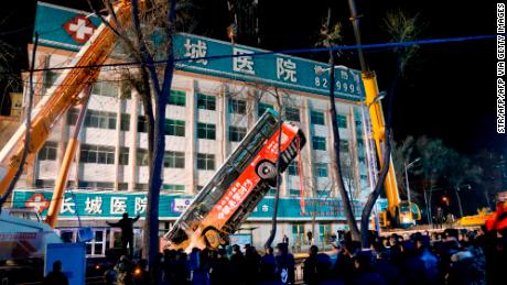 A bus swallowed by a huge sinkhole is lifted out after a road collapsed in Xining in China&#39;s northwestern Qinghai province.