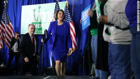 Klobuchar takes the stage with spouse John Bessler during a primary night event at the Grappone Conference Center on February 11, 2020 in Concord, New Hampshire. 