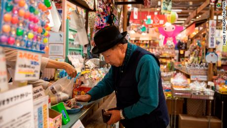 Iwao Hakamada buys himself an ice cream as he takes his daily walk around Hamamatsu,