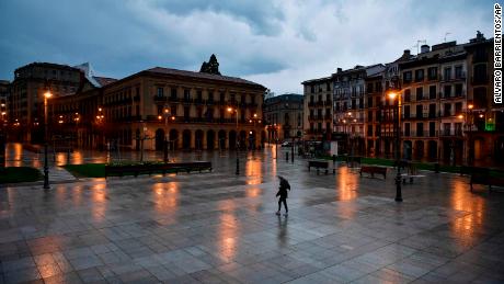 A person walks through an empty Plaza del Castillo square in Pamplona, northern Spain.