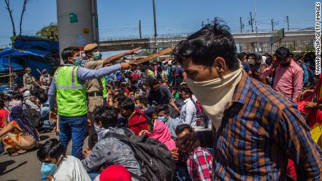 Les travailleurs migrants indiens coincés dans la capitale nationale tentent de monter dans des bus pour retourner dans leur village d'origine. 