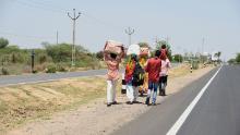 Les travailleurs migrants et les membres de leur famille marchent le long d'une autoroute dans une tentative désespérée de retourner dans leur village.
