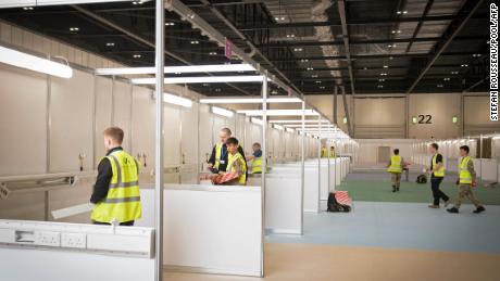 Soldiers and contractors build booths for hospital beds.