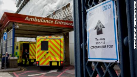 A sign points to a coronavirus testing pod, as an ambulance arrives at King&#39;s College Hospital in Camberwell, south London, on March 11.