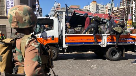 Obdachlose Südafrikaner in Johannesburg werden auf die Ladefläche eines Polizeiwagens geladen, wo ihnen mitgeteilt wurde, dass sie während der Sperrung in ein Tierheim gebracht werden würden.