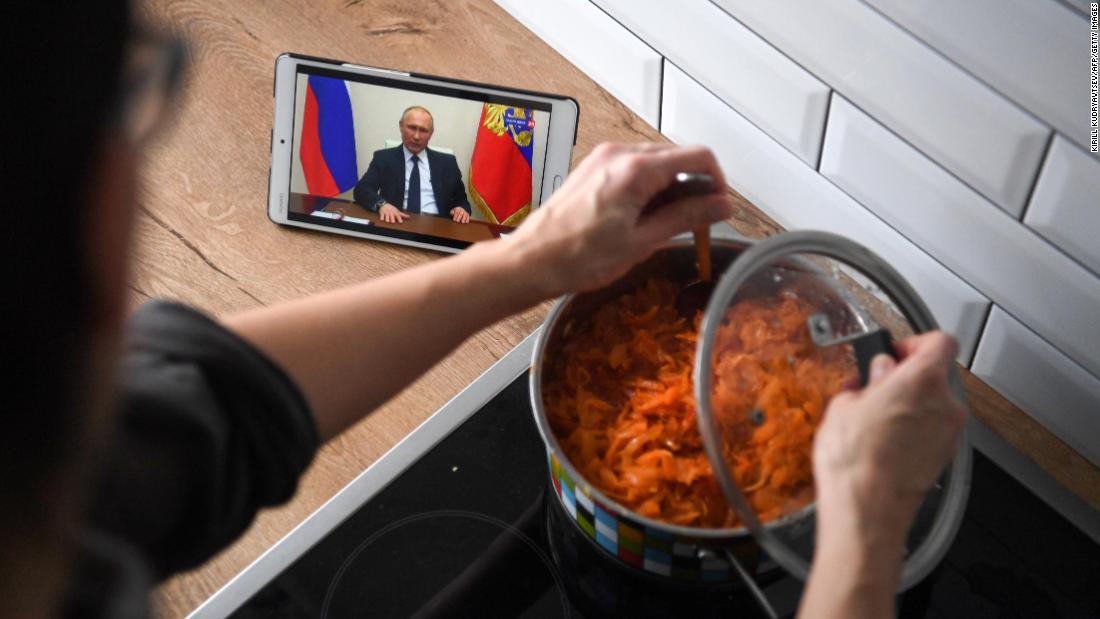 A woman in Moscow cooks while watching Russian President Vladimir Putin address the nation over the coronavirus pandemic.