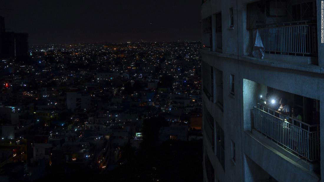 People shine lights from their balcony during a &lt;a href =&quot;https://www.cnn.com/2020/04/05/world/india-coronavirus-candlelight-vigil/index.html&quot; 目标=&quot;_空白&amp报价t;&gt;nationwide candlelight vigil&ltp;lt;/一个gtmp;gt; in Bangalore, 印度, 在四月 5.