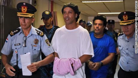 Ronaldinho și fratele său Roberto (dreapta) ajung la curtea Asuncion pentru a se prezenta în fața unui procuror.