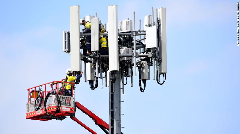 Telecommunications workers are seen working on a mobile cell tower in Sydney on Wednesday, March 25.
