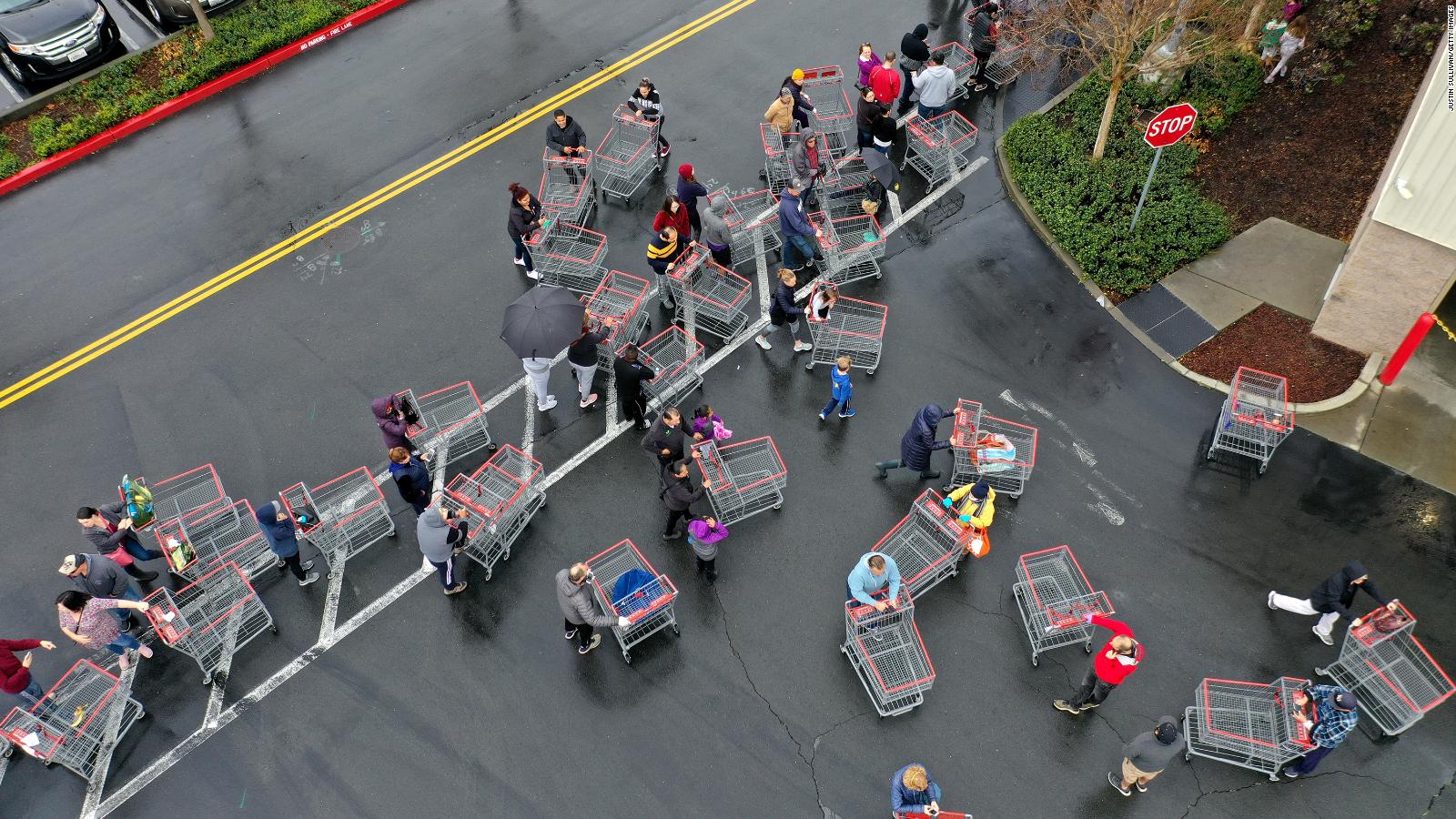 Hundreds of people line up to enter a Costco store in California.