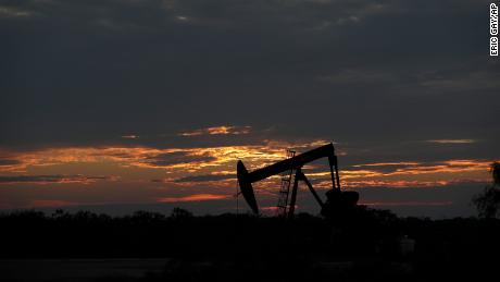 The sun sets behind an idle pump jack near Karnes City, Texas, Wednesday, April 8, 2020. Demand for oil continues to fall due to the new coronavirus outbreak. (AP Photo/Eric Gay)