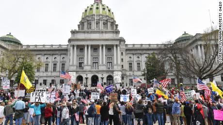 People take part in a &quot;reopen&quot; Pennsylvania demonstration on April 20, 2020 in Harrisburg, Pennsylvania. - Hundreds have protested in cities across America against coronavirus-related lockdowns -- with encouragement from President Donald Trump -- as resentment grows against the crippling economic cost of confinement.