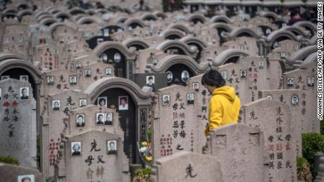 A woman decorates a grave during the Qing Ming festival, also known as Tomb Sweeping Day, at a cemetery in Shanghai on April 6, 2018. Traditional religious practice is growing in China, but the government tightly controls foreign faiths. 