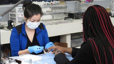 Xuan Le wears a mask as she works on the nails of Deriana Hayward at Envy Nail Bar on Friday, April 24, in Savannah.