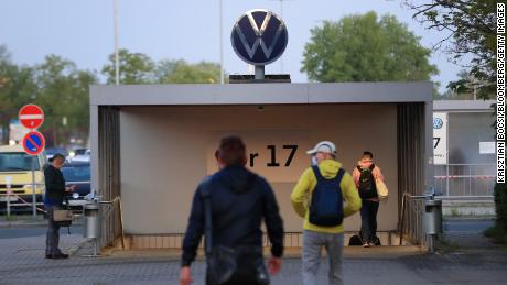 Die Mitarbeiter gehen am 27. April 2020 auf ein Eingangstor im Volkswagen Werk in Wolfsburg zu. 