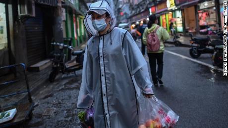 A person wearing a face mask as a preventive measure against the spread of the COVID-19 novel coronavirus carries groceries in a neighbourhood in Wuhan in China&#39;s central Hubei province on April 20.