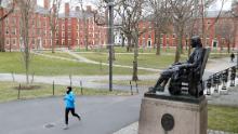 Un alergător traversează un Harvard Yard gol luna trecută, după ce elevii au fost solicitați să finalizeze semestrul online.