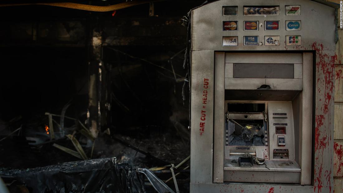 Red paint is seen on a burned ATM on Tuesday. The paint reads &quot;hair cut = head cut.&报价;
