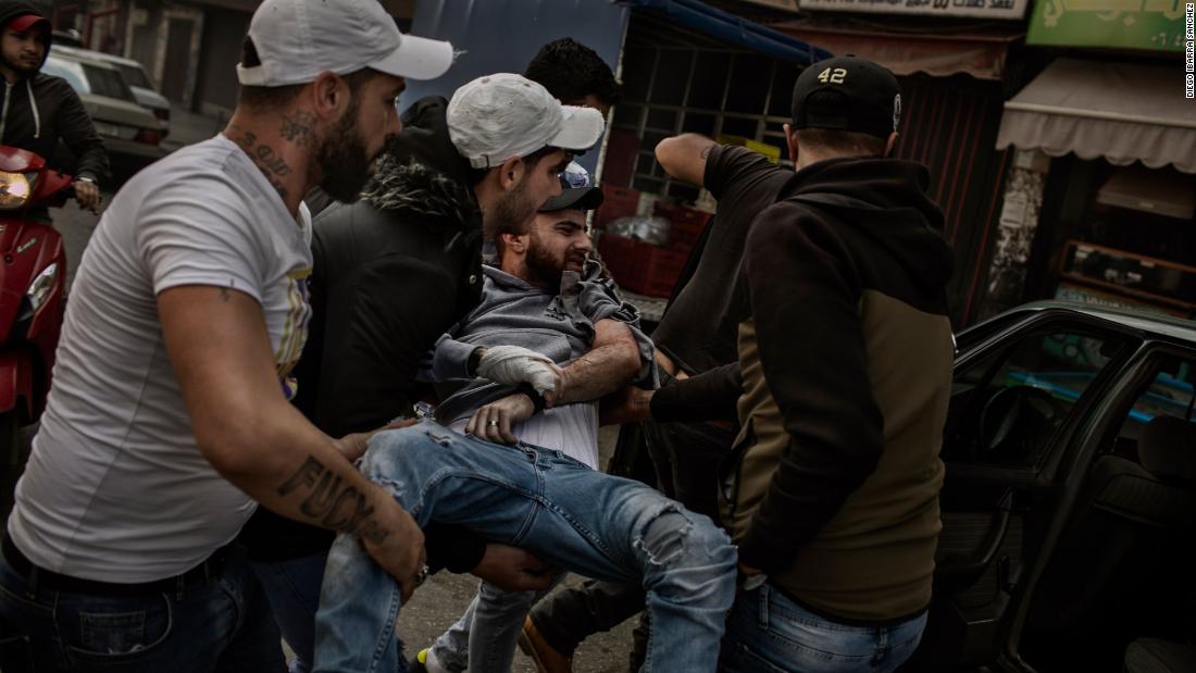 A protester is carried after being wounded by a rubber bullet.