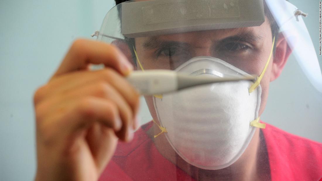 A health worker wears a face shield while checking a patient&#39;s temperature at a hospital in Toluca, メキシコ, 5月に 21. Mexico had reported its highest number of new daily cases.