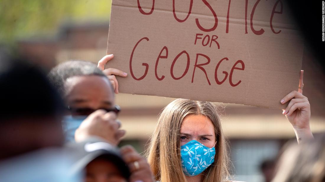 A Minneapolis demonstrator holds a sign reading &quot;Justice for George&kwotasie; op Mei 26.