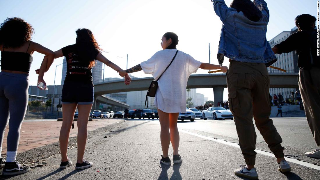 People join hands across a freeway in Los Angeles during a protest on May 27.