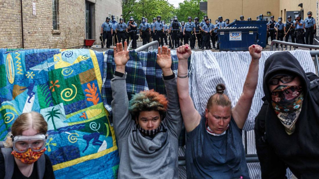 Protesters raise their hands up as they react to tear gas during a demonstration in Minneapolis on May 27.