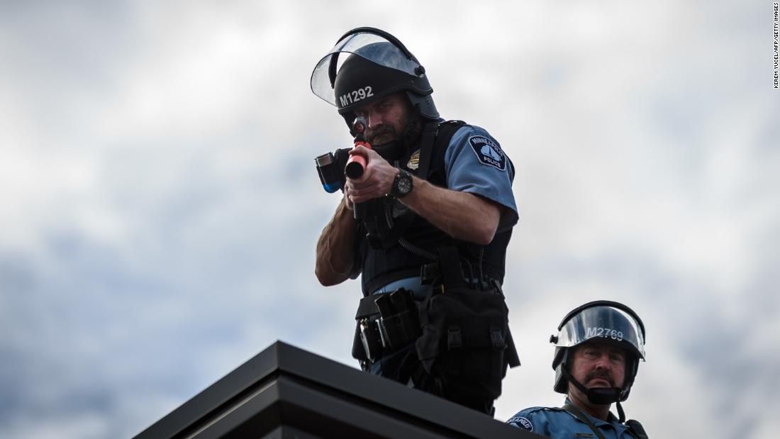 Two police officers stand on the roof of a Minneapolis police precinct during demonstrations on May 27.