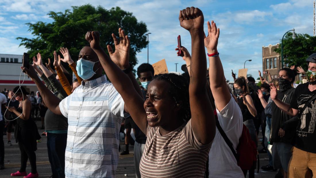 Demonstrators in Minneapolis raise their hands during a standoff with police on May 27.